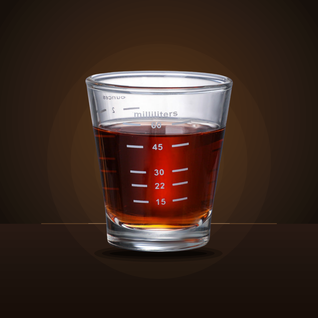 Espresso shot glass with measurement lines, filled with espresso